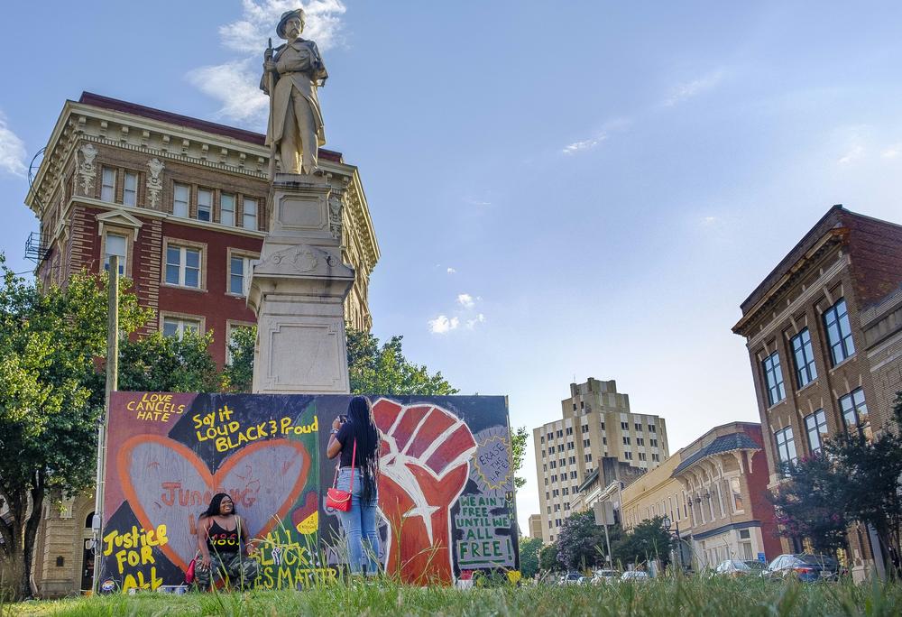 Visitors pose for pictures by the Black Lives Matter-themed art around the base of a Confederate monument on Cotton Avenue in Macon in the summer of 2020. The statue is one of two soon to be moved from downtown Macon.