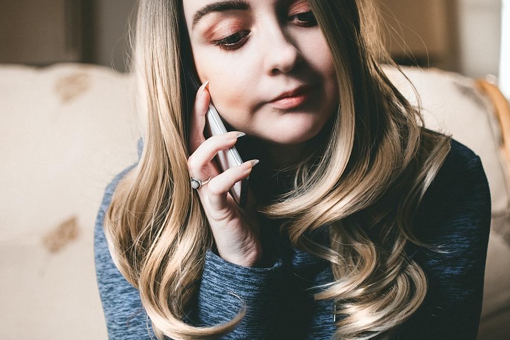 A woman holds a cell phone to her ear