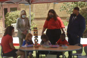 First lady Jill Biden and Education Secretary Miguel Cardona watch as children play a math game using wooden blocks at Horizons National summer learning program at the University of Georgia. 