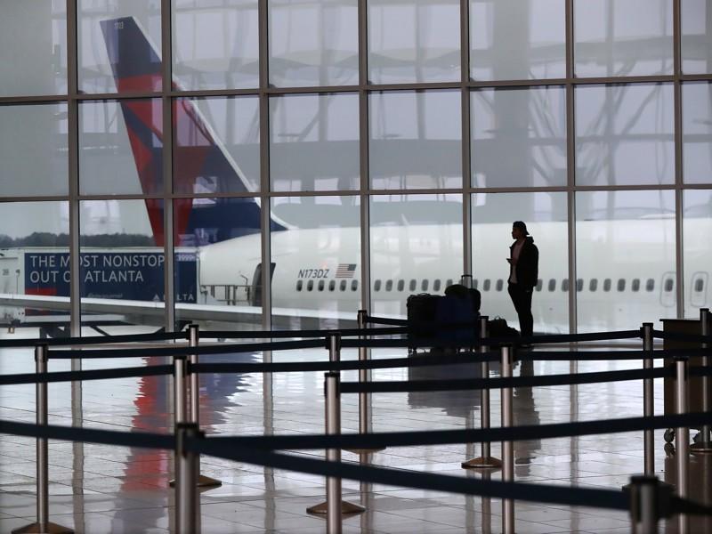 A Delta Air Lines plane sits at the International Terminal at Hartsfield-Jackson International Airport with a solitary international traveler trying to get a flight home amid European travel restrictions Monday, March 16, 2020, in Atlanta. International and domestic air travel has been hammered by the coronavirus. 