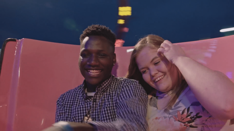 Two teens on a fair ride.