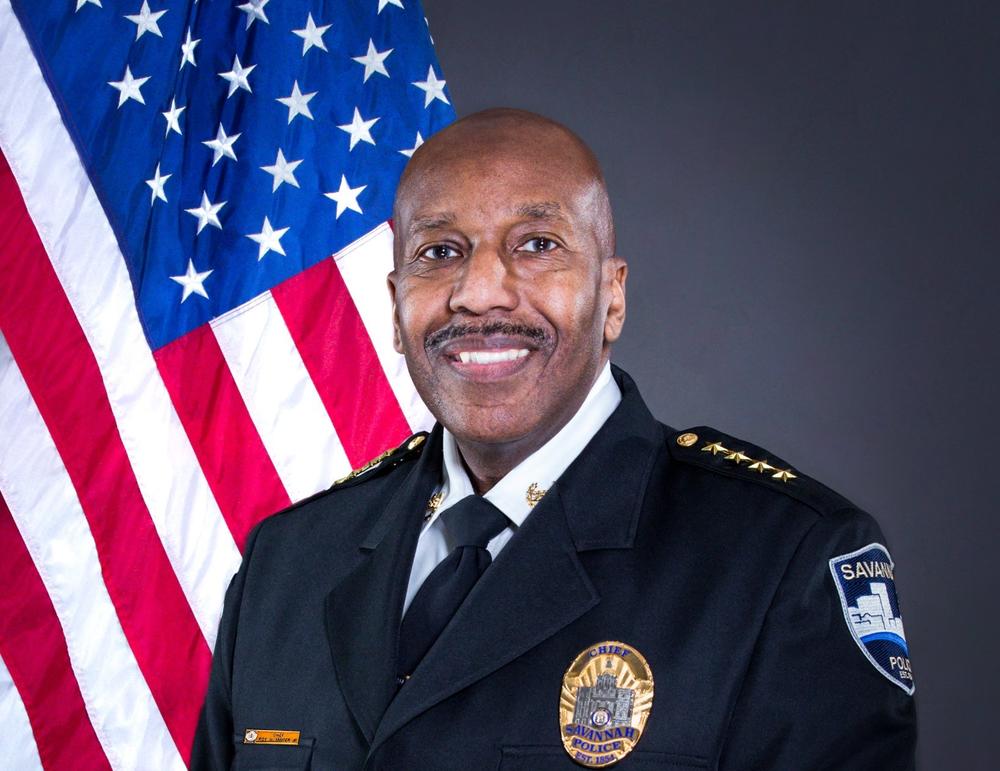 Portrait of former Savannah Police Chief Roy Minter in uniform in front of an American flag