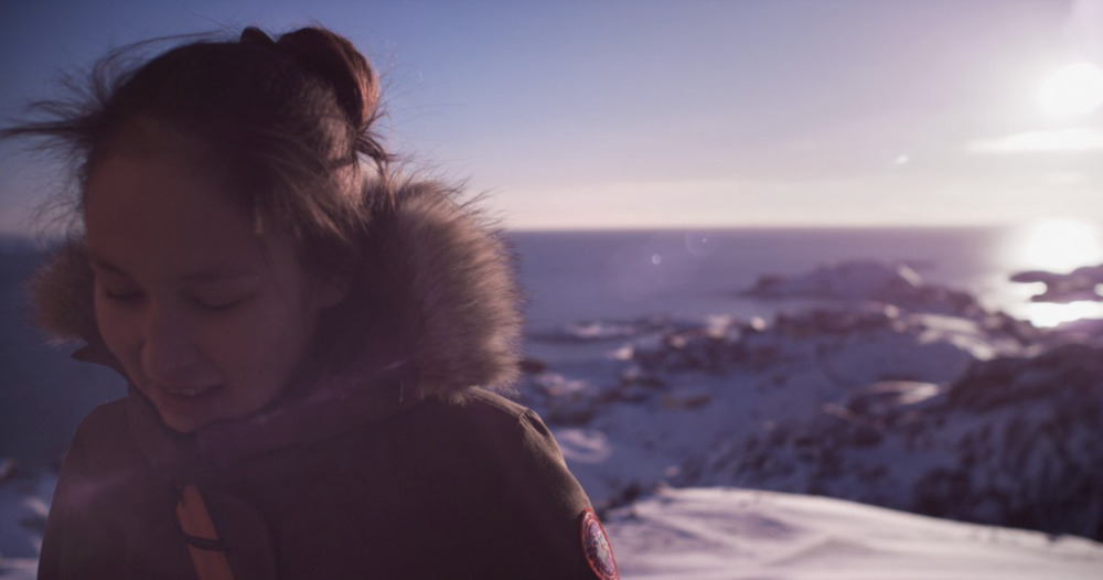 A young woman standing in a snowy landscape.