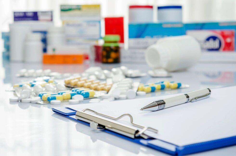 pills on a table next to a clipboard