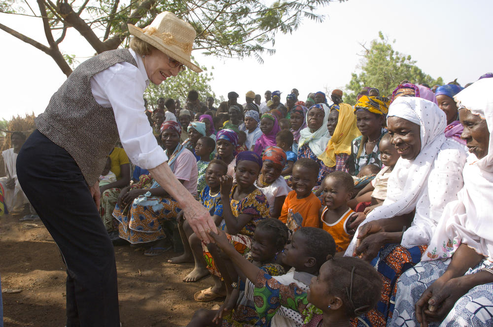 Former first lady Rosalynn Carter greets children in Tingoli, Ghana, during a Carter Center visit in 2007 to see the country's progress eradicating Guinea worm disease and controlling trachoma, a devastating eye disease. 