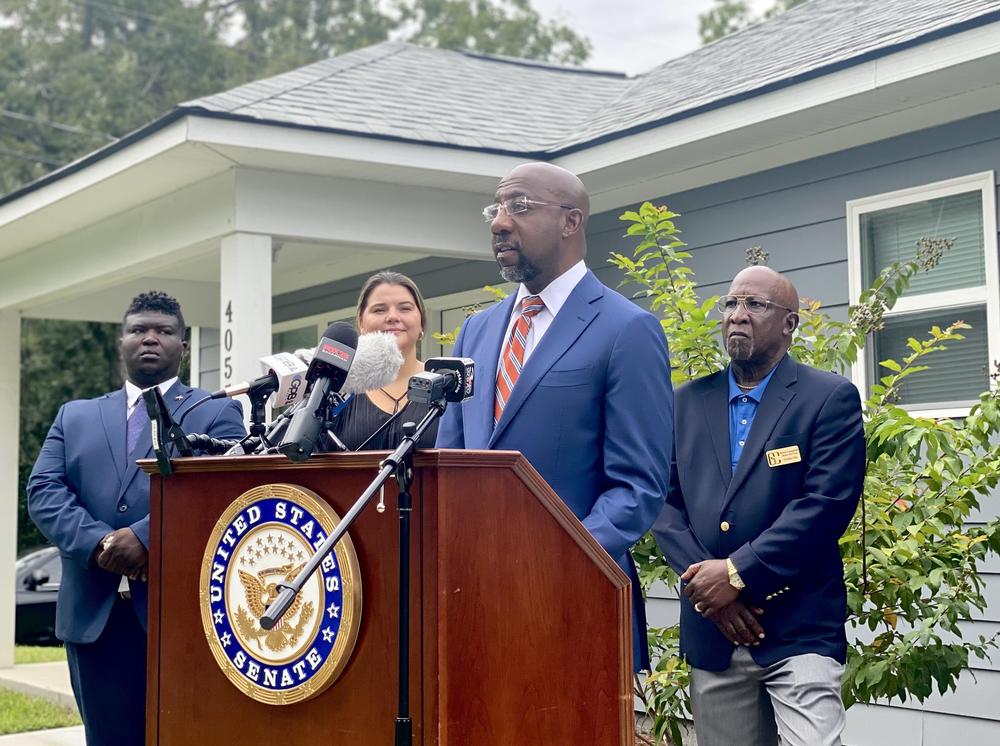 Sen. Raphael Warnock discusses newly introduced housing legislation outside of a house in Garden City.