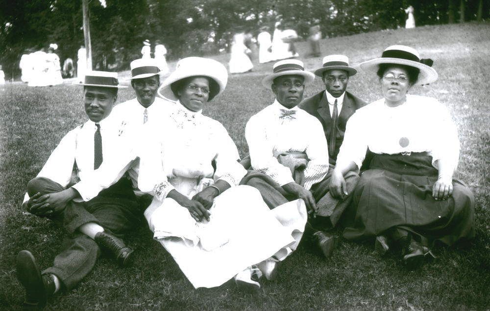 A photograph of a black family relaxing in a park from the early 20th century.