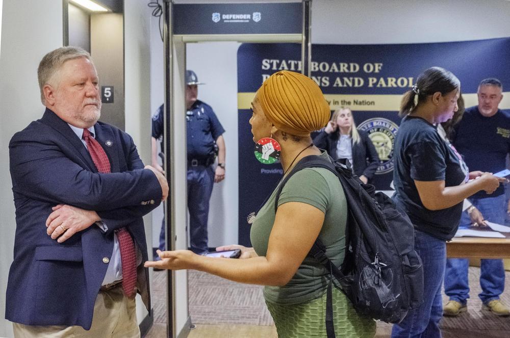 Andrea Guice, right, talks to Georgia Board of Pardons and Parole spokesperson Steve Hayes after the board's September meeting. Guice's brother has served 8 years in prison after his first possible parole date.