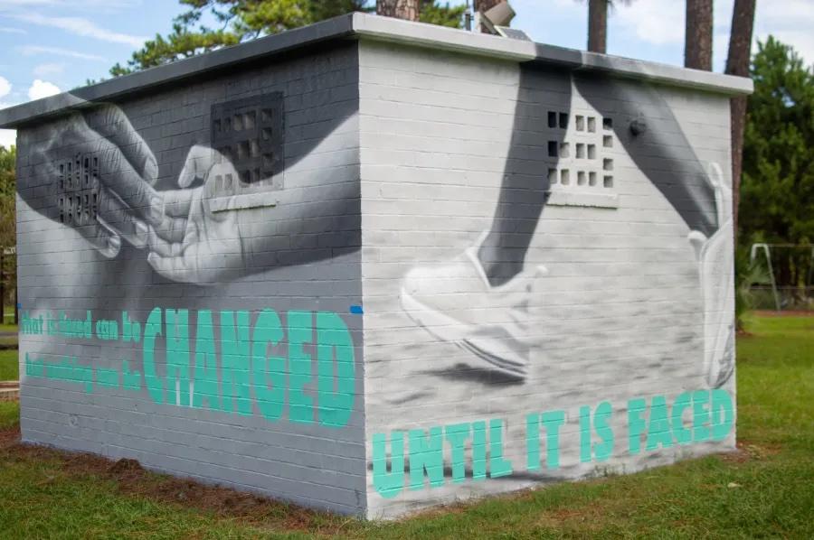 This mural, located on a building in Ahmaud Arbery Park on Townsend Street across from Whitlock Street in Brunswick, Ga., is inspired by Arbery, who was killed in 2020 while jogging in a white neighborhood nearby. The mural quotes James Baldwin: "Not everything that is faced can be changed, but nothing can be changed until it is faced."