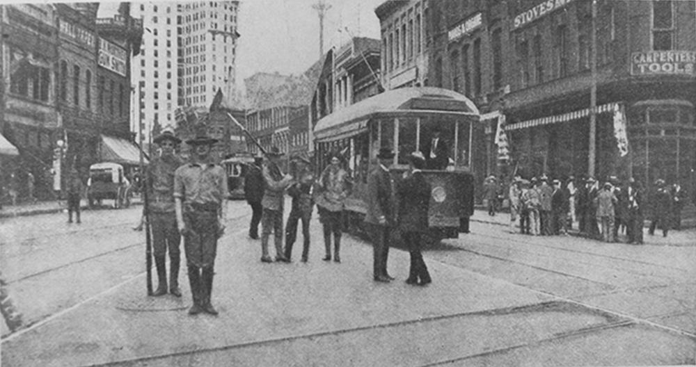 A black and white photo from 1906 shows armed militiamen patrolling the streets of downtown Atlanta.