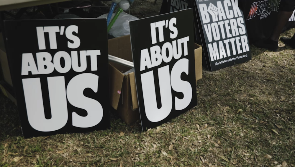 Signs are seen in a voting rights demonstration in Coffee County.