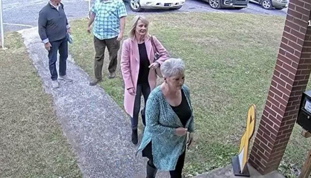  A video surveillance image taken on Jan. 19, 2021, shows former Coffee County Republican Party chair Cathy Latham, bottom right, welcoming forensic computer analysts with Atlanta-based SullivanStrickler to the county elections office. Screenshot from Coffee County video