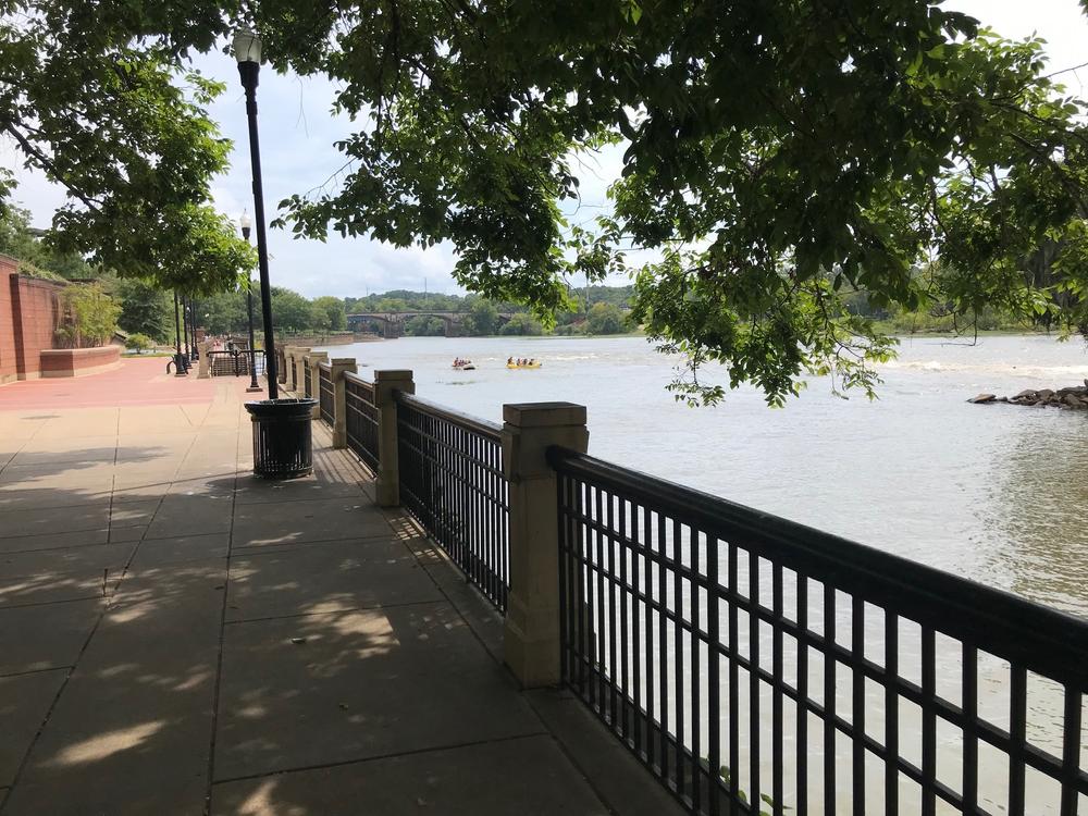 The Columbus waterfront is shown with a walkway and shady tree.