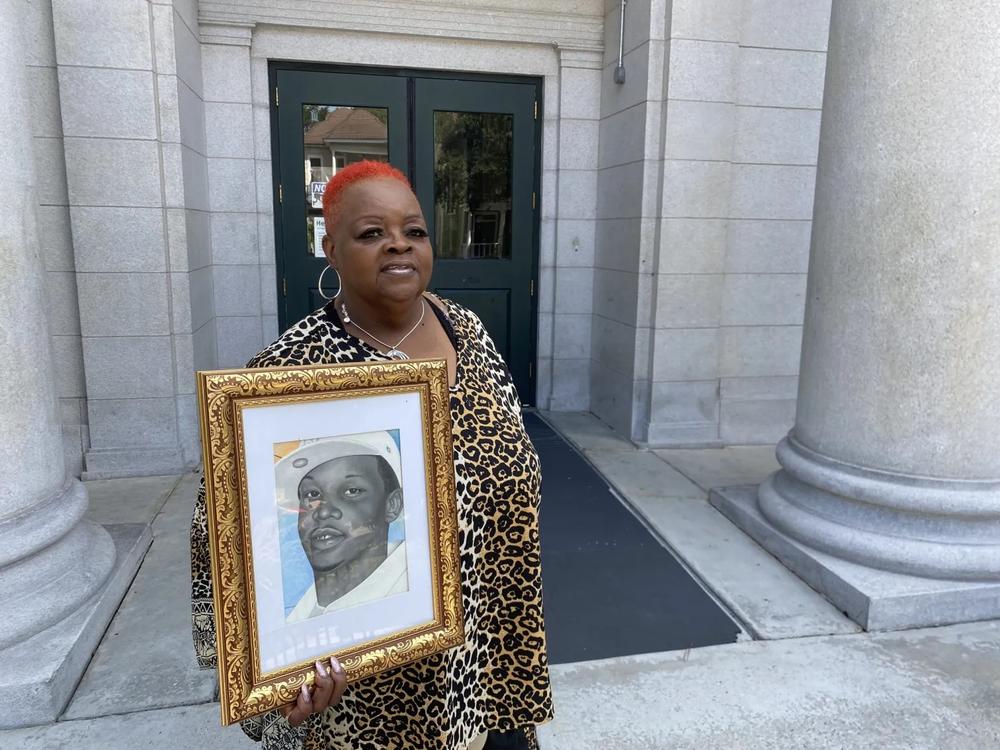Janice Hall stands outside the Bull Street Library on Sept. 16, 2022, holding a picture of her son, Curtis, whose murder has gone unsolved by Savannah Police for over a decade. Jake Shore/The Current