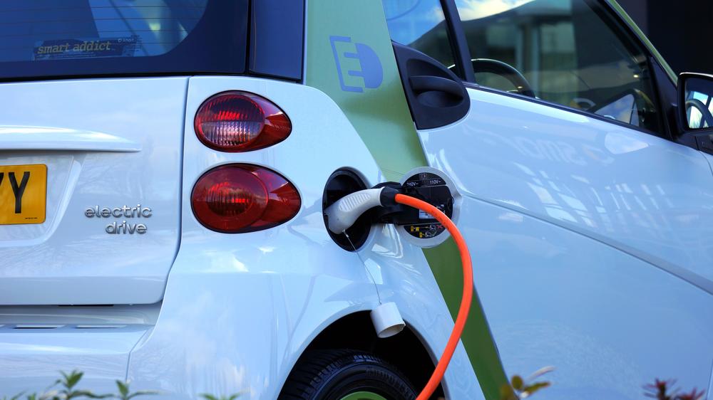 Electric vehicle plugged in at charging station.