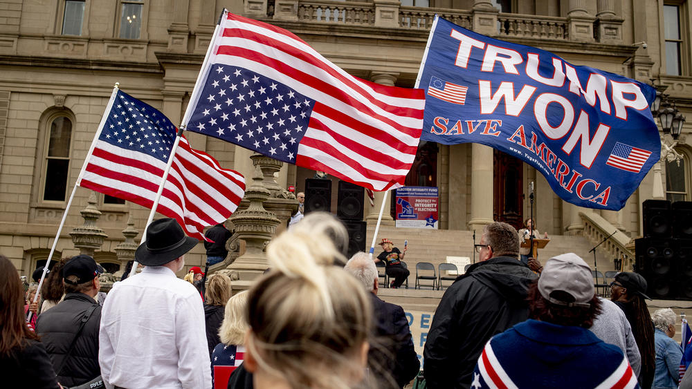 People at a rally holding flags.