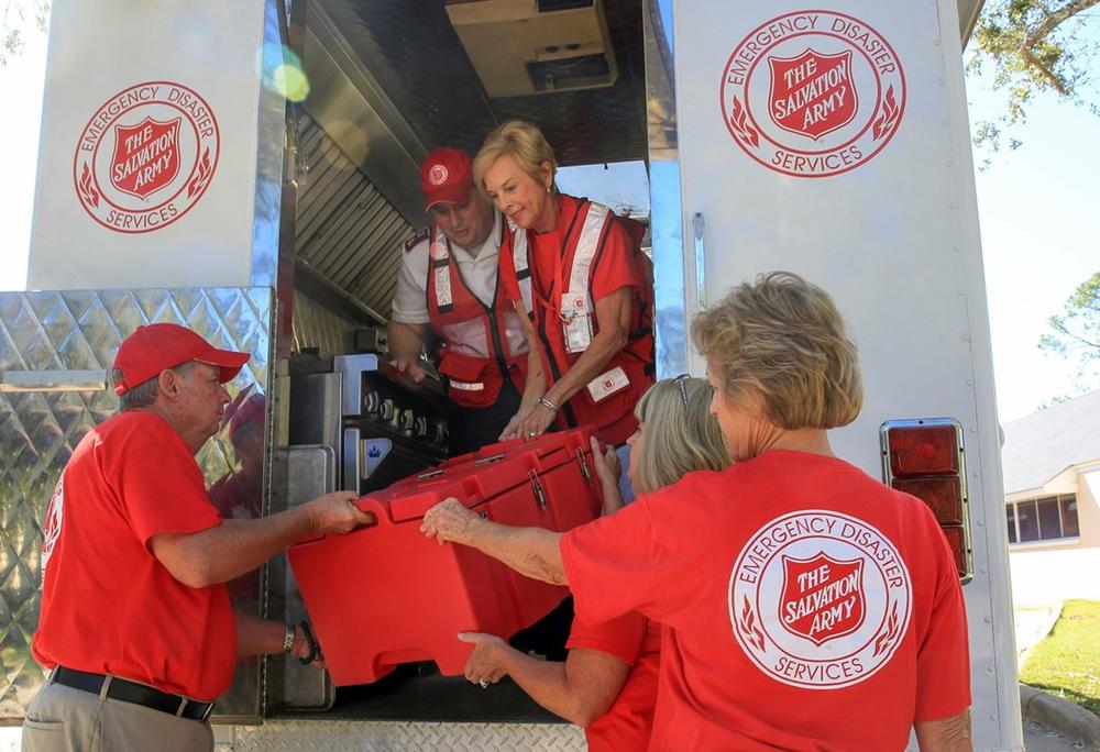 Volunteers unload cargo from a Salvation Army truck.