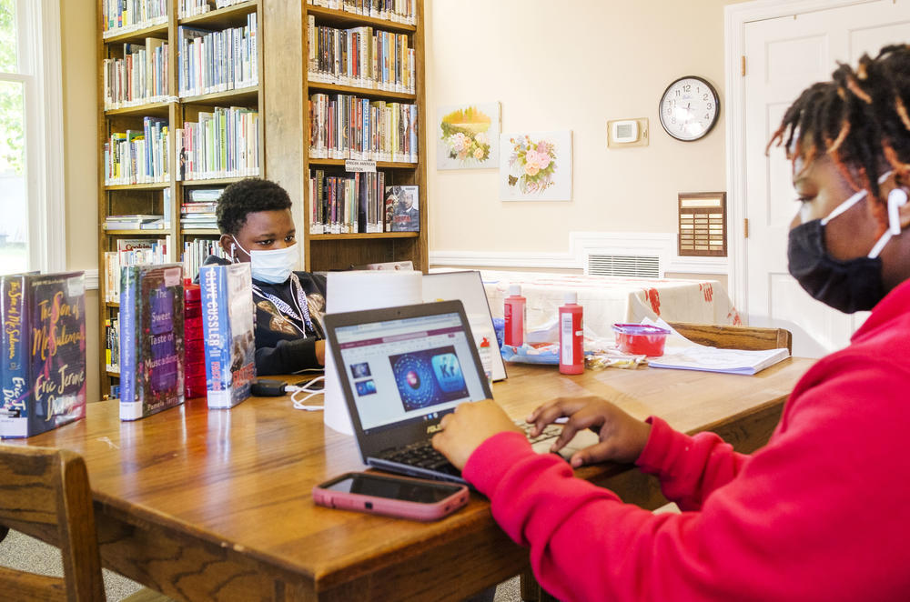 Siblings Quinyonna Tooks, right, and Charles Knott do their schoolwork via WiFi in the Oglethorpe Library in Macon County in 2021. The COVID pandemic made clear disparities in high speed internet access between urban and rural Georgia. 