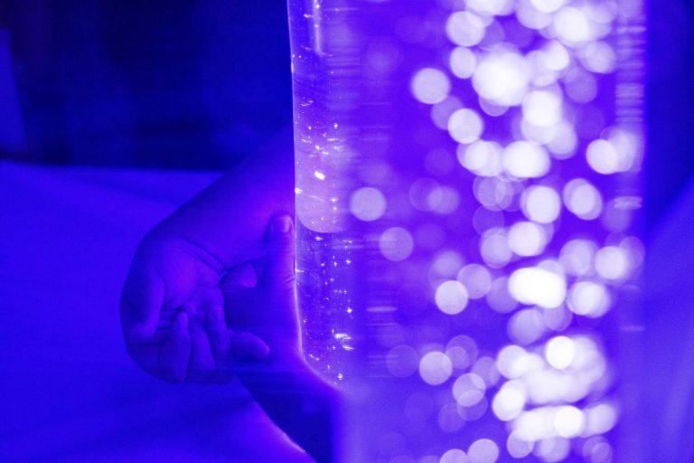 A Central High School student hugs a column of bubbles in the sensory room on Oct. 25, 2022. (Grant Blankenship | Georgia Public Broadcasting)