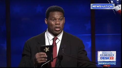 Herschel Walker holds up badge.