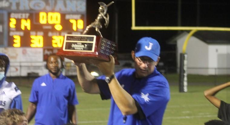 Coach Don Norton holds last year's region championship trophy.