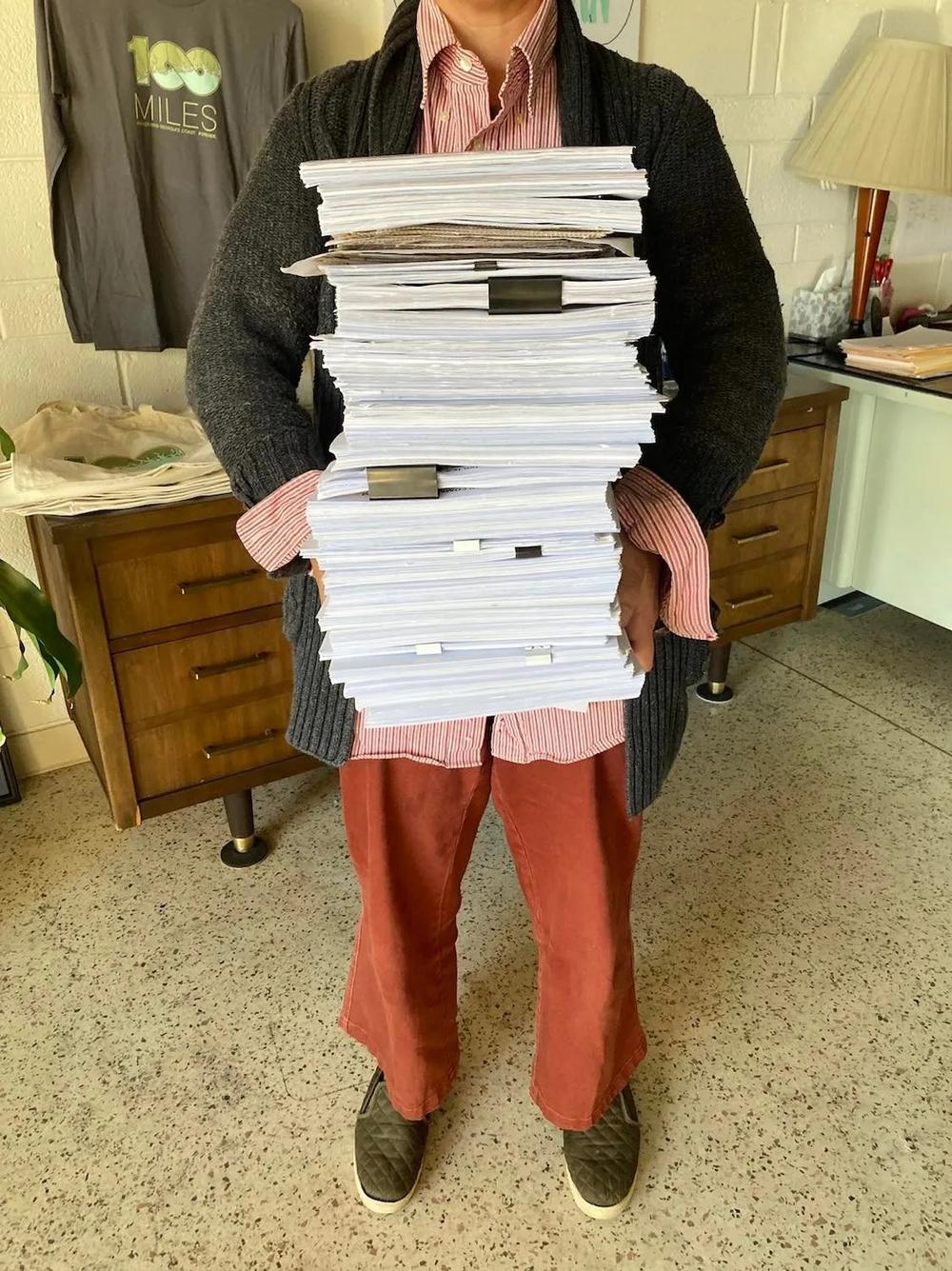 Megan Desrosiers holds the stack of petitions collected to force a referendum on the purchase of land for Spaceport Camden. Credit: One Hundred Miles