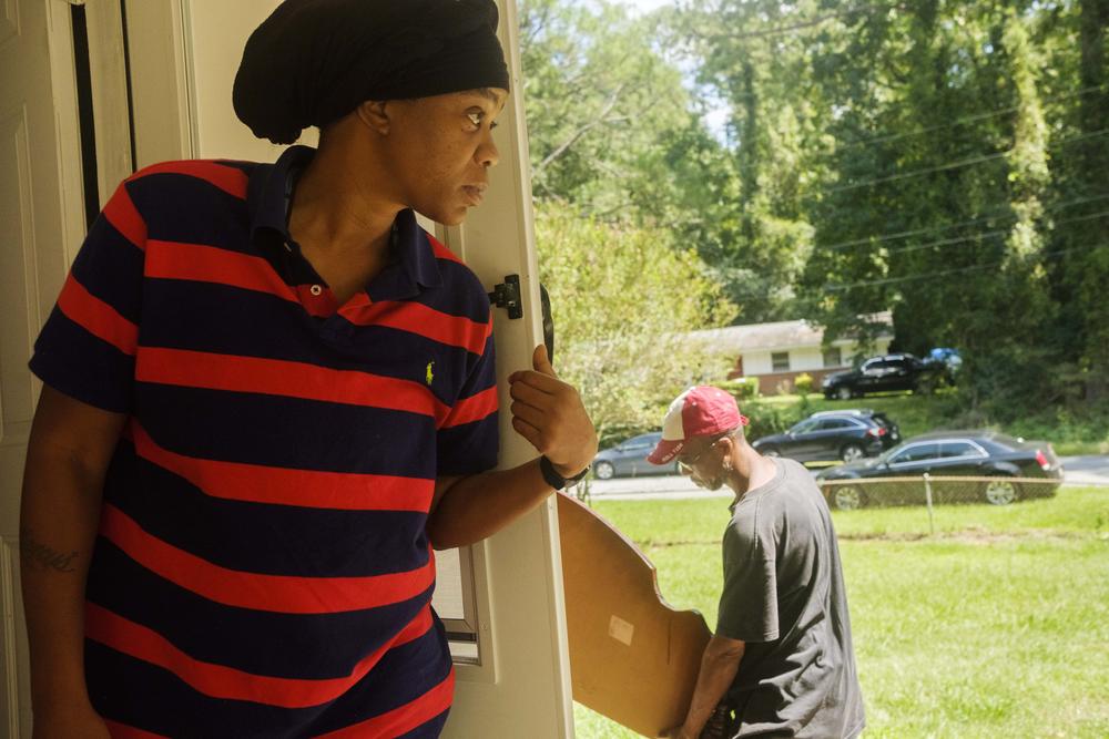 LaShundra Thomas in the doorway of her new home in Columbus. A string of deadbeat landlords in Atlanta left Thomas without adequate housing.