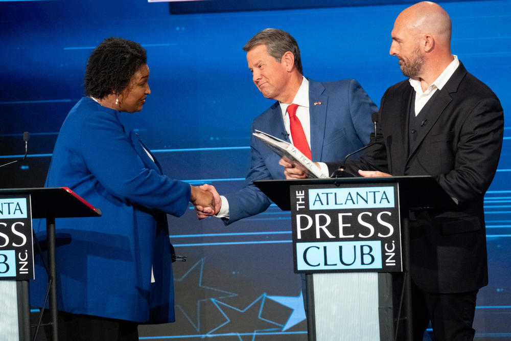  Democrat Stacey Abrams and Gov. Brian Kemp shake hands after Monday’s Atlanta Press Club Loudermilk-Young Debate Series in Atlanta, as Libertarian candidate Shane Hazel looks on. Early voting also started Monday for the Nov. 8 election. AP Photo/Ben Gray