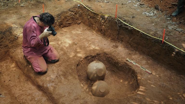 A person taking photographs at an archaeological site.