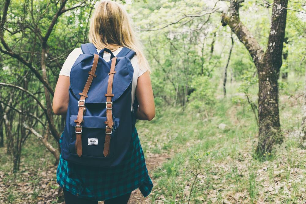 girl with backpack in woods