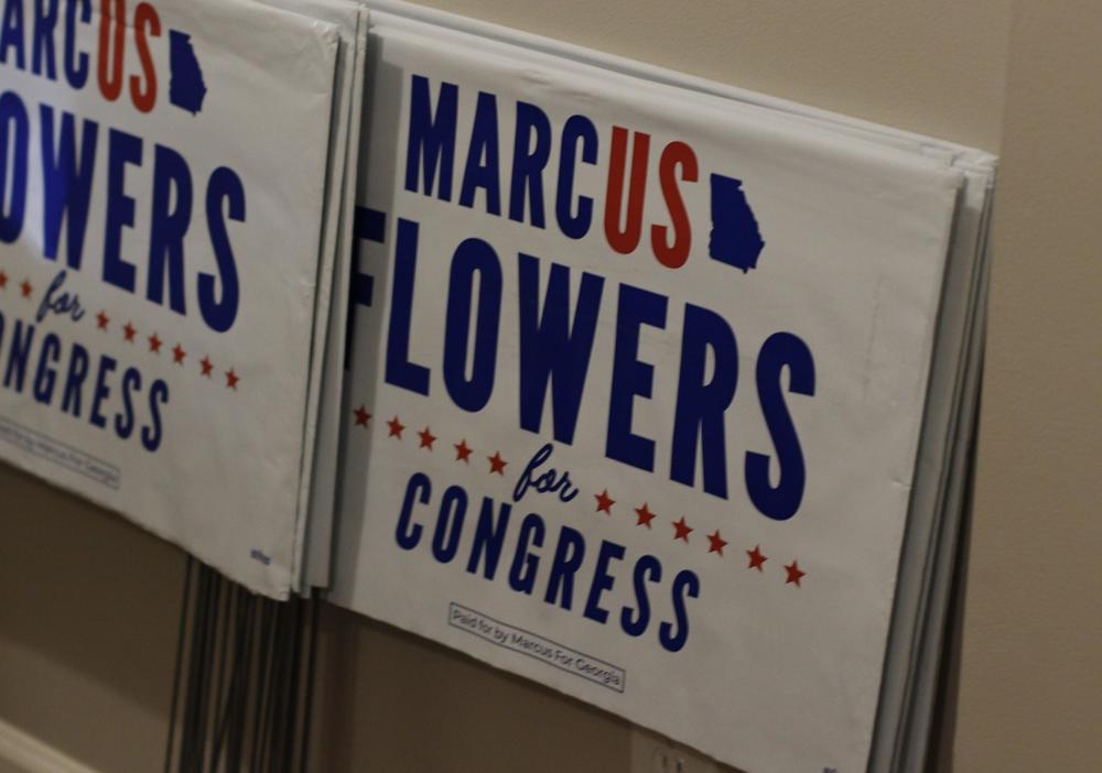 Marcus Flowers signs at a campaign event at a home in Acworth, Ga.
