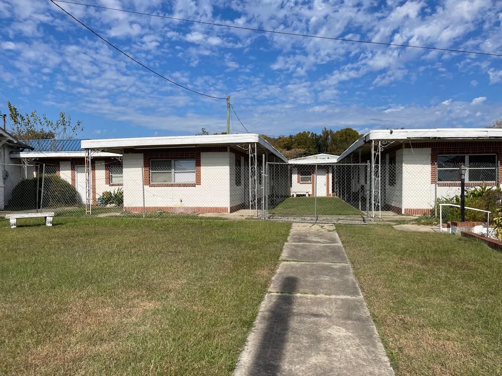 Squat one-story buildings surrounded by chain link fence comprise the former Dudley Motel, which was opened in 1958 to accommodate Black travelers during the tumultuous civil rights era.