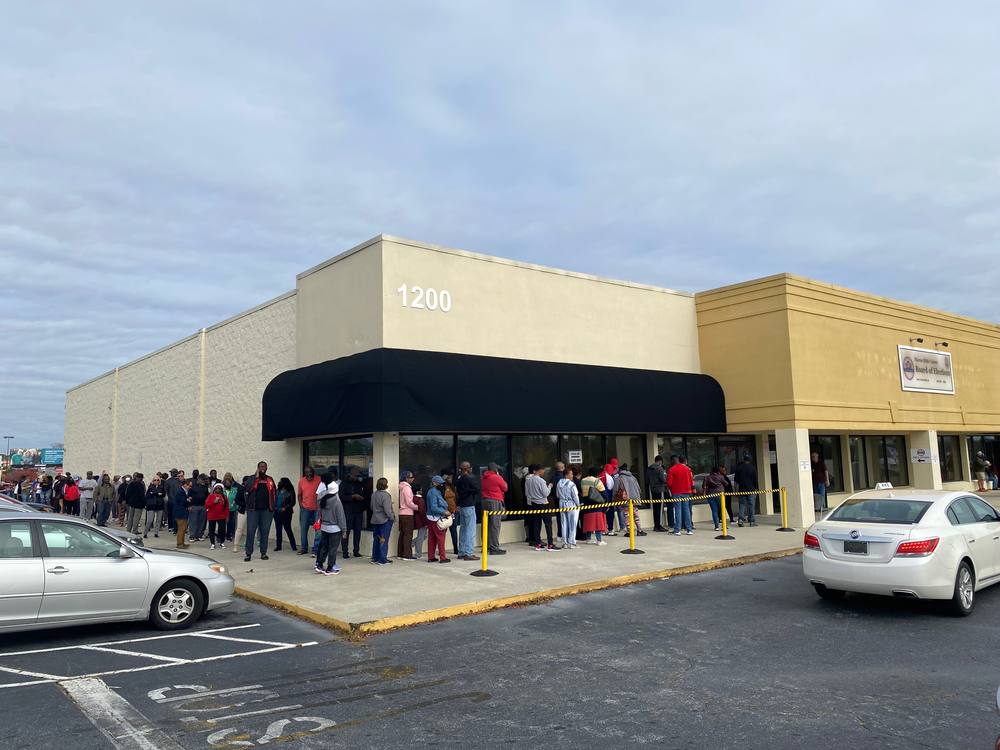 A long line of voters wait to cast ballots in Macon, Ga. on Saturday, November 26, 2022.