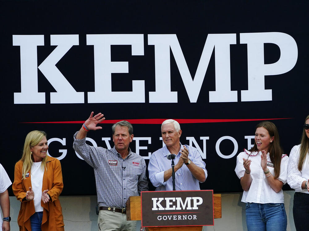 Republican Gov. Brian Kemp, second from left, and former Vice President Mike Pence acknowledge the crowd during a campaign rally for Kemp's reelection bid, Tuesday, Nov. 1, 2022 in Cumming, Ga., as First Lady Marty Kemp, left, and daughter Amy Porter Kemp look on . (AP Photo/John Bazemore)