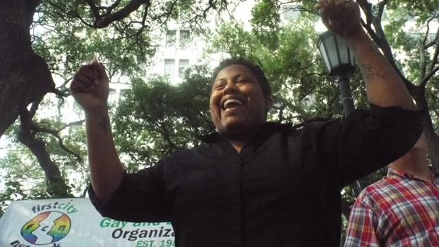 Candace Hardnett is shown raising her hands in celebration.