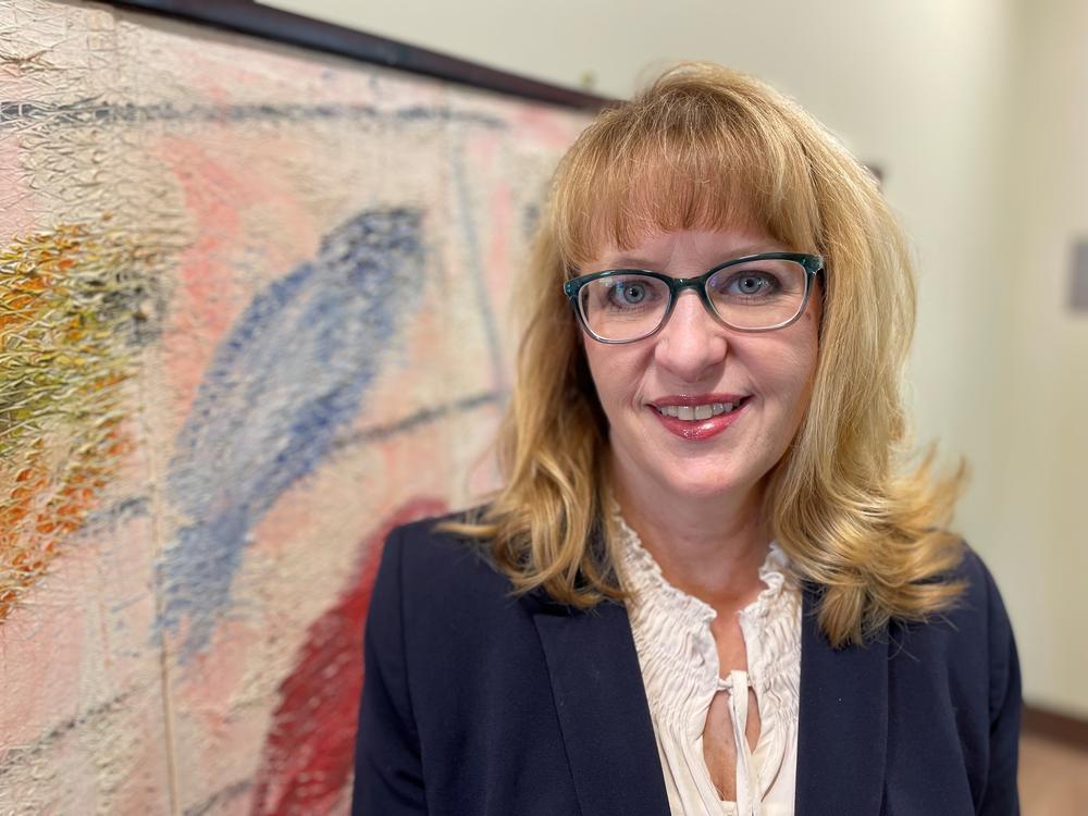 Dr. Julie Battle stands in front of a paintng in Brenau University's Lynn J. Darby School of Psychology and Adolescent Psychology.