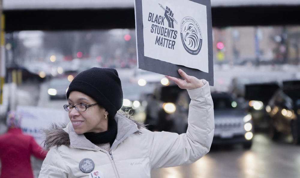 A woman smiling at a protest.