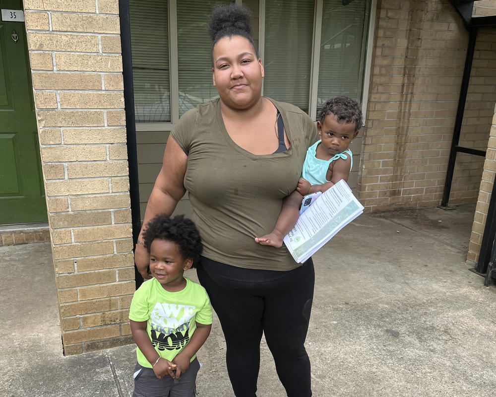 Louana Joseph with her son, M.J. (left), and her infant daughter, Marlie, outside their former apartment complex in southwestern Atlanta. Joseph moved out of the unit because she suspected the gray and brown splotches that were spreading through the unit were mold. After rents soared during the pandemic, some families were forced to live in substandard housing, which increased their risk for health problems such as asthma and lead poisoning.