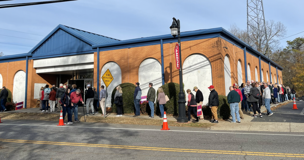 Voters wait in a line wrapped around the Albert L. Stone Elections Building in Canton, Ga., to vote early on Friday, Dec. 1 in the 2022 Georgia Senate runoff elections.