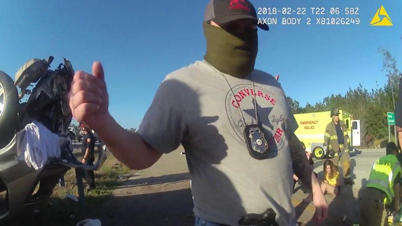  A masked Glynn County narcotics unit officer at the scene of a February 2018 crash, where GBNET officers allegedly sought to cover up their involvement. Credit: Body camera screenshot