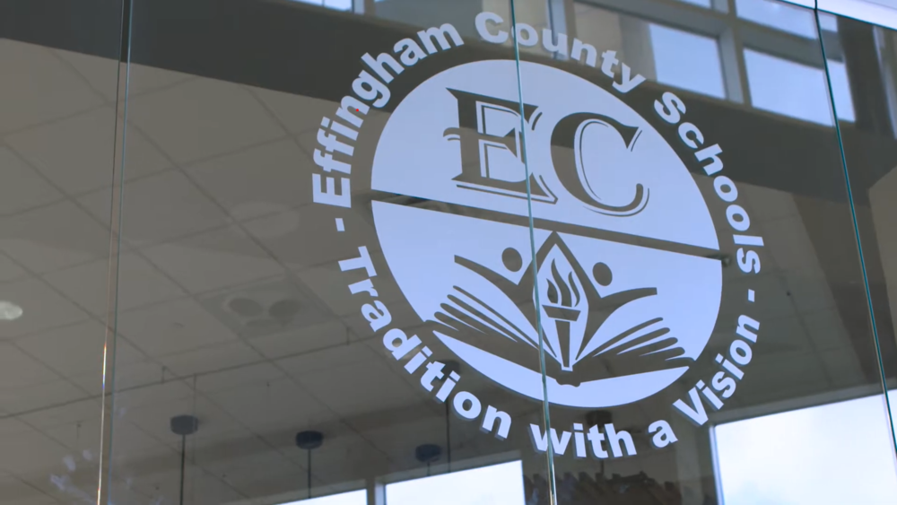 The Effingham County School District logo is displayed on a clear glass wall inside a building.