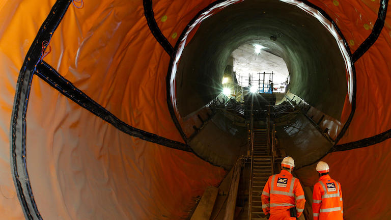 Engineers in a tunnel in protective gear.