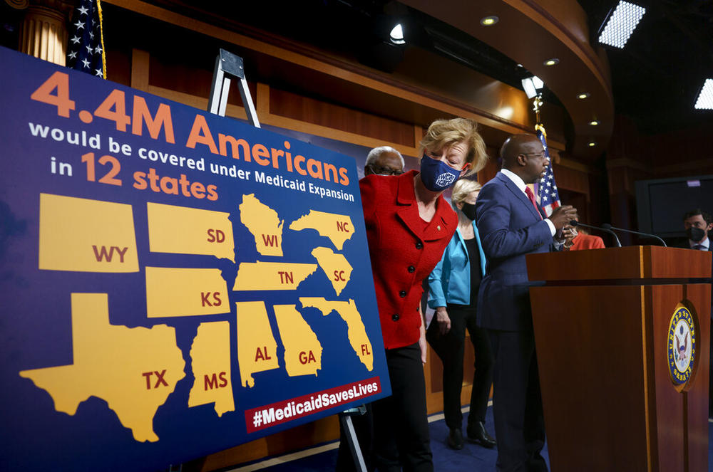 a woman looks at a chart about Medicaid expansion