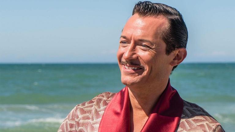 A smiling man on a beach.