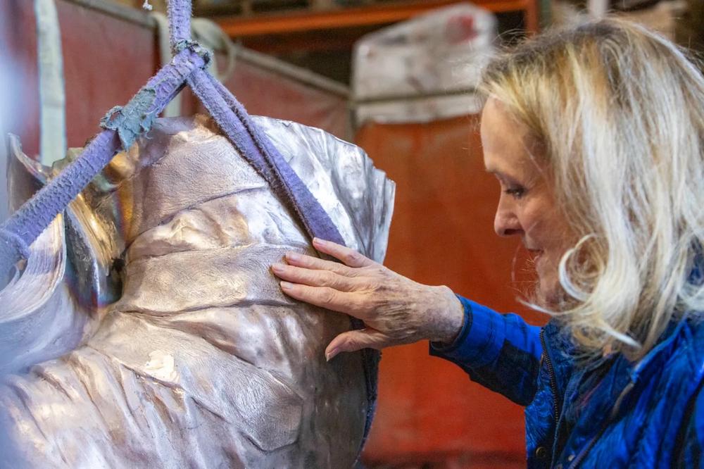 Artist Kathy Fincher examines a detail of a sculpture of Dr. Martin Luther King Jr.
