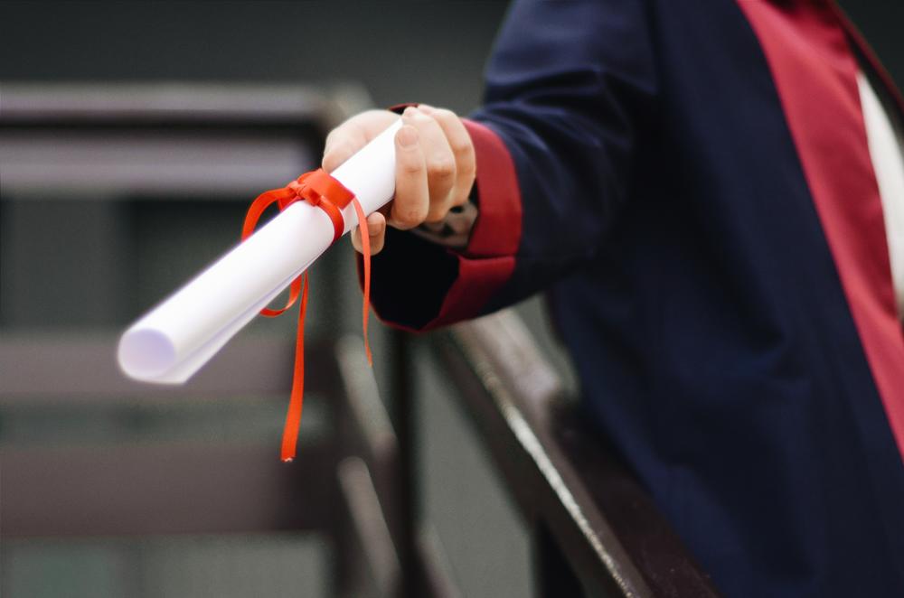 Hand holding a college diploma.