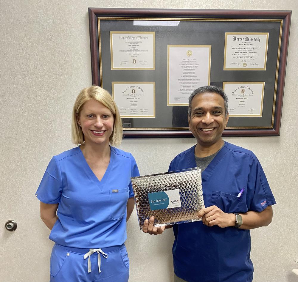 Meredith Parrish and Dr. Sudhir Athni hold the Syn-One Test in the Macon office.
