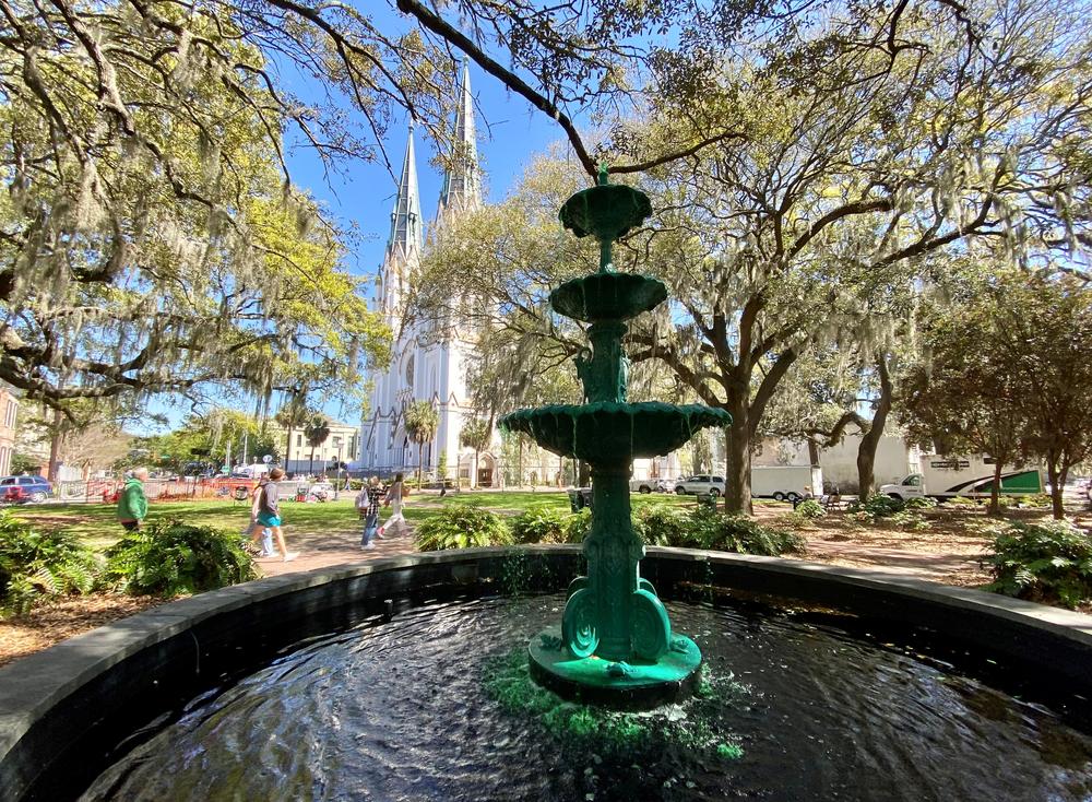 The Savannah St. Patrick's Day parade will pass by several downtown squares, including Lafayette Square, where the fountain's water has been dyed green. The parade will begin after morning mass at the Cathedral Basilica of St. John the Baptist, seen here in the background.