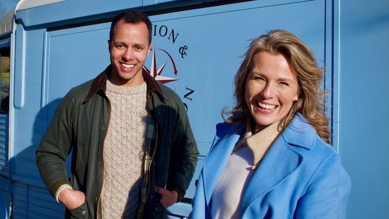 A man and woman standing in front of a truck smiling.