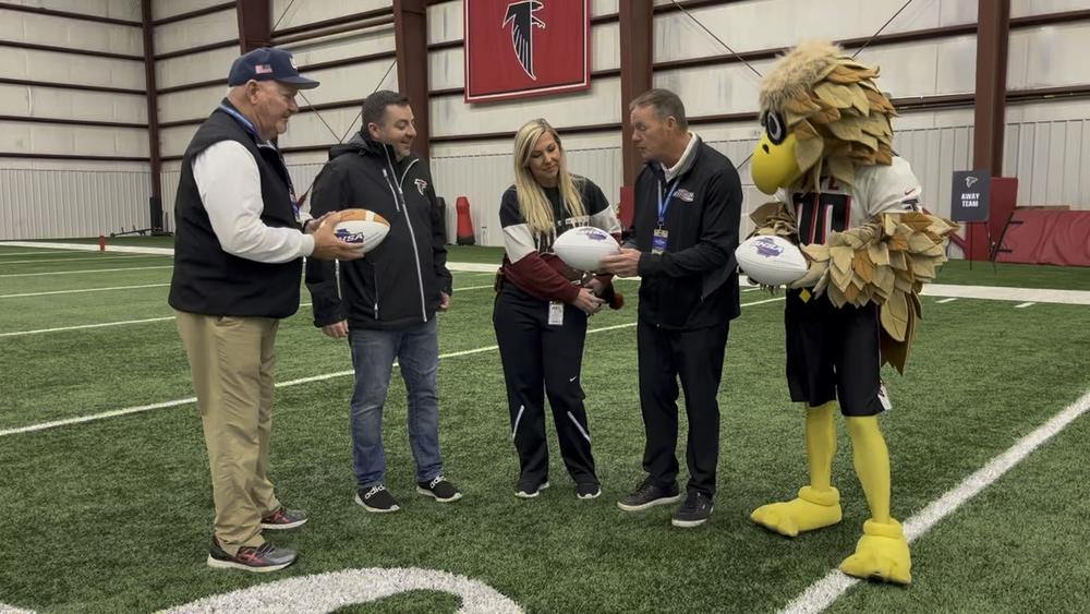 The Georgia High School Association honored the Atlanta Falcons during the 2022 girls flag football semifinals. Pictured from left to right: Asst. Executive Director of the GHSA Ernie Yarbrough, Vice Pres. of Community Relations at Falcons Chris Millman, Director of Community Relations at Falcons Amanda Dinakle, Executive Director of the GHSA Dr. Robin Hines, Freddie the Falcon.